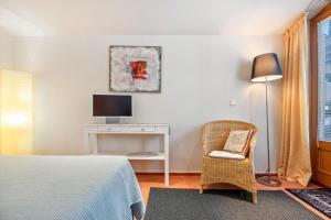 a bedroom with a bed and a chair and a television at room4you in Hemmingen