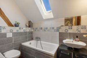 a bathroom with a sink and a tub and a toilet at Ferienwohnung Klosterheide in Lindow +10 photos