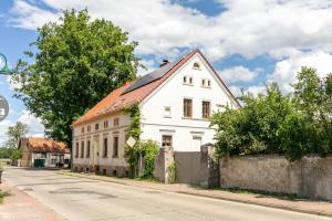 a white house with a red roof on a street at Ferienwohnung Klosterheide in Lindow