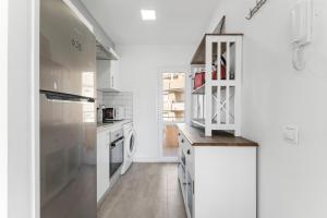 a white kitchen with a refrigerator and a dishwasher at Antogil-mata1 in La Mata +20 photos