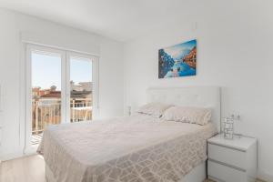 a white bedroom with a bed and a window at Antogil-mata1 in La Mata