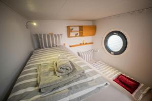 a small room with a bed with towels on it at Luxuriöses Hausboot Roma Woma D13 in Fürstenberg