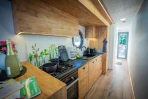 a kitchen with wooden cabinets and a stove top oven at Luxuriöses Hausboot Roma Woma D13 in Fürstenberg +15 photos