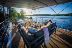 a boat with couches and a table on the deck at Luxuriöses Hausboot Roma Woma D13 in Fürstenberg