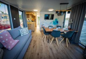 a living room with a blue couch and a table at Luxuriöses Hausboot Roma Woma D13 in Fürstenberg