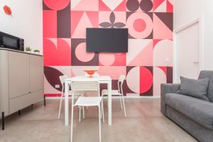 a living room with a table and chairs and a tv at Taormina Center Suite with Jacuzzi in Taormina