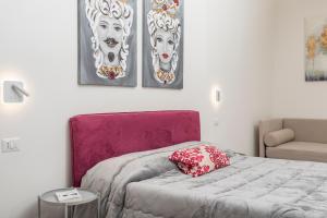 a bedroom with a bed with two masks on the wall at Taormina Center Suite with Jacuzzi in Taormina