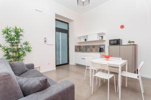 a living room with a couch and a table and chairs at Taormina Center Suite with Jacuzzi in Taormina