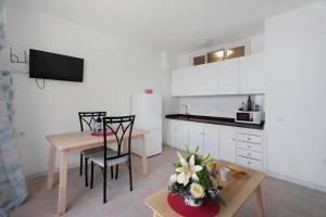 a kitchen with white cabinets and a table and chairs at Apartamentos Playa Azul - 8 in Vallehermoso