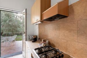 a kitchen with a stove top oven next to a balcony at Agriturismo Green House in Santo Stefano al Mare