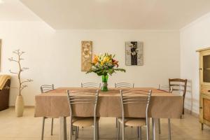a dining room table with a vase of flowers on it at Duplex Pedroza in Pozo Izquierdo +18 photos