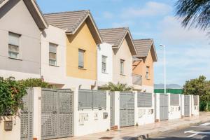 a row of houses with a fence at Duplex Pedroza in Pozo Izquierdo