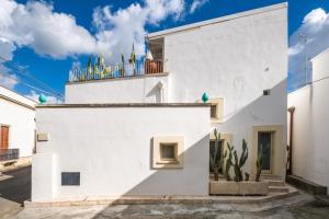 a white house with a cactus on the roof at Nuvò-Lux e Spa in Veglie