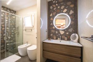 a bathroom with a sink and a toilet and a mirror at Nuvò-Lux e Spa in Veglie +21 photos