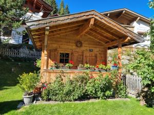 a wooden shed with awning in a yard at Haus Daniela in Gerlos