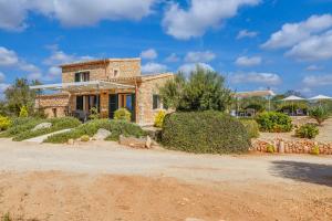 a stone house in the middle of a yard at Villa Gemma in Ses Salines