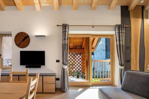 a living room with a television and a balcony at Dimora Vacanze in Mezzano