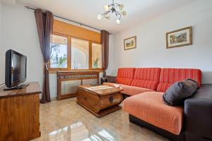 a living room with a red couch and a tv at Torre Piquer in Berge