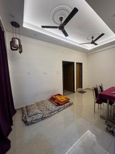 a room with a ceiling fan and a bed on the floor at Spiritual Oasis in Rishīkesh