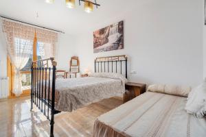 a bedroom with two beds and a couch at Torre Piquer in Berge