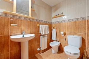a bathroom with a white toilet and a sink at Torre Piquer in Berge +25 photos