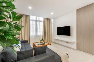 a living room with a couch and a tv at Sunlit Modern Stay in Arona