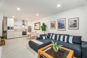 a living room with a black couch and a table at Sunlit Modern Stay in Arona