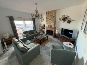 a living room with two couches and a tv at Casa Montelado in Mijas