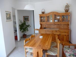 a dining room with a wooden table and a cabinet at Apartments Porto Ottiolu Mare in Porto Ottiolu