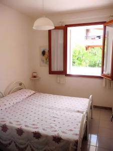 a bedroom with a bed and a window at Apartments Porto Ottiolu Mare in Porto Ottiolu