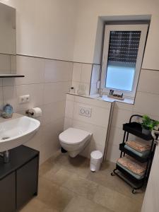 a bathroom with a toilet and a sink and a window at Rike in Oesterdeichstrich +13 photos