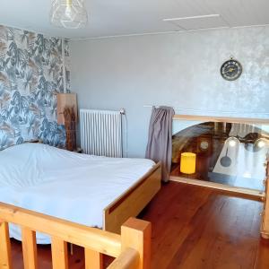 a bedroom with a bed and a wooden floor at Gîte Du Recoux in Le Recoux