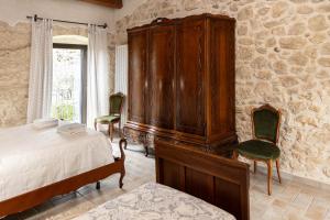 a bedroom with a large wooden cabinet and two chairs at Masseria del Ponte in Pretoro