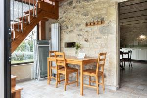a wooden table and chairs in a room with a stone wall at Masseria del Ponte in Pretoro +21 photos
