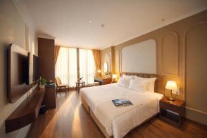 a hotel room with a bed and a television at L'amant de Hanoi Hotel in Hanoi