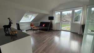 a living room with a couch and some windows at Gästehaus Babel in Pfronten