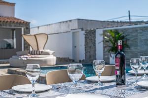 a bottle of wine sitting on a table with wine glasses at Casa El Buda in Vejer de la Frontera