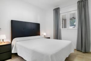 a bedroom with a large white bed and a window at Casa El Buda in Vejer de la Frontera +21 photos
