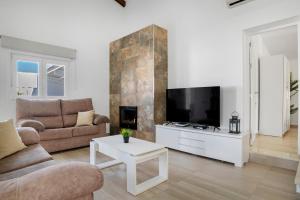 a living room with a couch and a tv at Casa El Buda in Vejer de la Frontera
