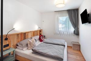 een slaapkamer met een bed en een televisie aan de muur bij Cesa Pattis in Mazzin