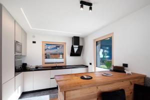 een keuken met witte kasten en een houten tafel bij Cesa Pattis in Mazzin