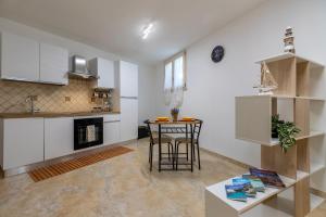 a kitchen and living room with a table and a counter at L'Angolo Monolocale- Porto Torres in Porto Torres