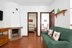 a living room with a green couch and a fireplace at Casa Paqui 2 in Roche +20 photos