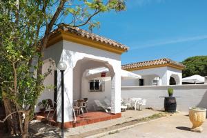 a white house with a patio with chairs and tables at Casa Paqui 2 in Roche