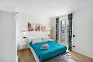 a white bedroom with a blue bed and a window at Principe Di Agerola in Agerola