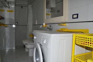 a bathroom with a washing machine and a toilet at Appartamento Ll06 a 60m dal mare in San Foca +24 photos