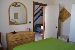a bedroom with a bed and a mirror and a staircase at Appartamento Ll06 a 60m dal mare in San Foca