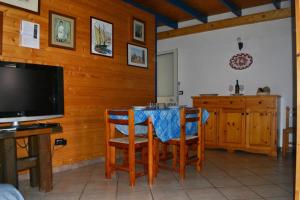 a dining room with a table with chairs and a television at Appartamento Ll06 a 60m dal mare in San Foca
