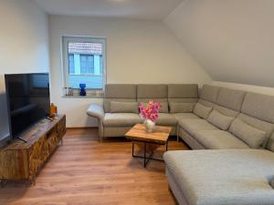a living room with a couch and a table with flowers at Ferienquartier alte Bäckerei in Feldberg