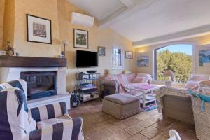 a living room with a fireplace and a tv at Villa - La Mignonette avec terrasse in Cavalaire-sur-Mer